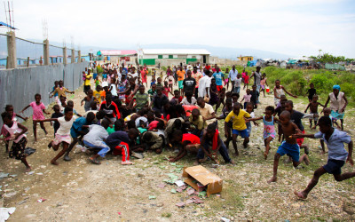 Children and other people of community dispute food, Port-au-Prince, Haiti, 2012.