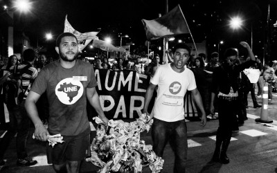 Attention call: protesters carrying a turnstile that will be burnt, Belo Horizonte, Brazil, 2014.