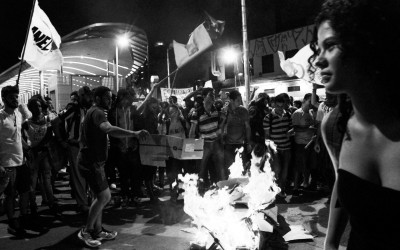 Protester jumping on the burning turnstile , Belo Horizonte, Brazil, 2014.
