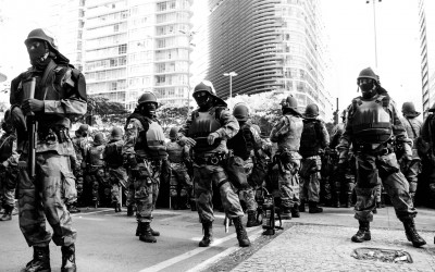 Polices in barriers protecting themselves against lacrimogenic gas, Belo Horizonte, Brazil, 2014.