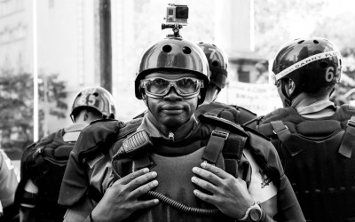 Polices in barriers protecting themselves against lacrimogenic gas, Belo Horizonte, Brazil, 2014.
