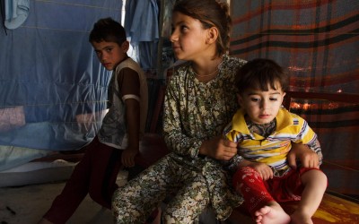 Children inside the family hair salon located at Sharia Refugee Camp. Because of the lack of schools for all children and the lack of availability of parents who need to work to earn a living income, they spend the day sitting looking out for each other. Near Duhok, Iraq (Iraqi Kurdistan).
