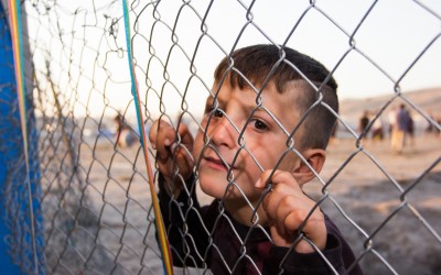 Child grabbing a fence in the Cover II Refugee Camp. Since the refugee camp’s schools are not able to hold all the children, many of them spend their days wandering in the camp instead of going to school. Besides the lack of space in the classrooms, there isn’t enough food, school supplies and clothes. Hussein, the child’s father, confides: “It’s a pity what I envision, for our future should be done for them – for the children. What will the future look like?” Near Duhok, Iraq (Iraqi Kurdistan).