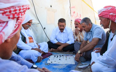 Men playing a traditional board game. Being very easy going and happy, the Kurds are always surrounded by friends and good humoured. In the weekends they spend hours together playing board or card games, Near Erbil, Iraqi Kurdistan, 2015.
