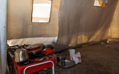 Interior of one of the Refugee Camp Cover II residential tents. In a space of approximately 3 to 4m2, entire families re-create the chests of the house according to the time of day. At night, they put on mattresses and in the morning pick them up to be able to use the makeshift kitchen and be able to walk. Near Duhok, Iraq (Iraqi Kurdistan).