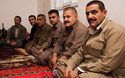 Commanders of the Peshmergas discussing new strategies against the Islamic State (ISIS) While they rest for the next round of battles. At these times, they talk, take the typical black tea and watch television. Iraq (Iraqi Kurdistan), Middle East, 2015.