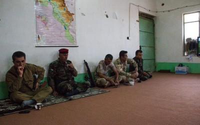 Commanders of the Peshmergas discussing new strategies against the Islamic State (ISIS) While they rest for the next round of battles. At these times, they talk, take the typical black tea and watch television. Iraq (Iraqi Kurdistan), Middle East, 2015.